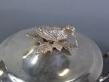 a silver plate with a bird on top of it