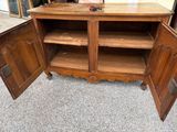 a wooden cabinet with a door open on the floor