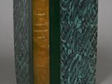 an old book with a green cover sitting on top of a table