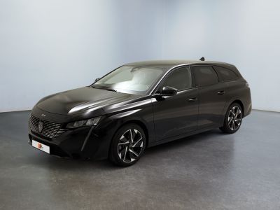 La voiture grise est garée dans une pièce aux murs blancs.