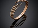 un gros plan d'un bracelet en or serti de diamants sur fond noir
