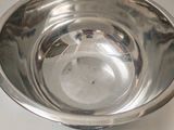 a silver bowl and a silver plate on a white table
