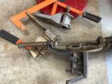 a clamp, wrench, and other tools on the floor