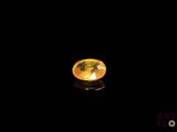 a close up of a yellow diamond on a black surface