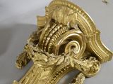 a gold clock that is on a white table
