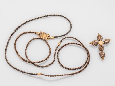 un gros plan d'un collier, d'un bracelet et d'une bague posés sur une surface blanche