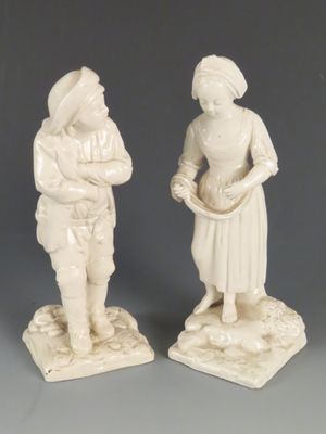 deux figurines d'un homme et d'une femme debout l'un à côté de l'autre