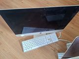 a computer monitor, keyboard and mouse on a wooden floor