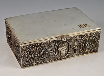 une boîte ancienne en argent posée sur une surface blanche, sur laquelle figure un numéro