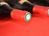 several bottles of wine are lined up on a red table