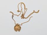 an image of a gold necklace with a flower design on it