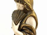 statue of a woman holding a fan and a fan in her hand