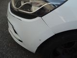 a white car that has been damaged and is parked on the side of the road