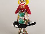 figurine représentant un clown tenant un plateau de bonbons sur fond blanc