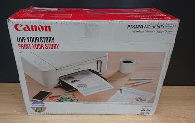 une boîte contenant une imprimante Canon Pixma posée sur une table en bois