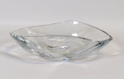 un saladier en verre transparent posé sur une surface blanche, avec un fond blanc