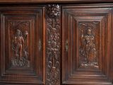 carvings on the sideboard of a large wooden cabinet with carvings on the doors