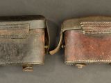 two pieces of silver and brown leather on a gray surface