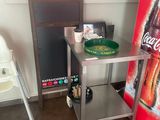 une chaise haute à côté d'une table sur laquelle est posée une affiche Coca-Cola