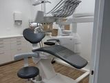 an image of a dentist ' s office with a chair and dental equipment
