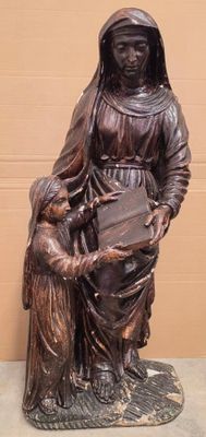 bronze statue of a woman holding a child and a book