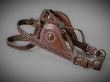 brown leather dog harness with metal buckles on a gray background