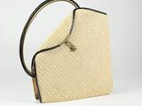 a close up of a straw bag with a handle on a white background
