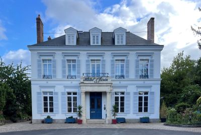 a large white house with a blue door and windows