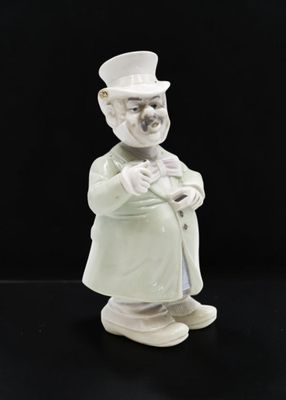 une figurine représentant un homme avec un chapeau et une canne