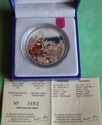 a silver coin in a blue box on a green surface