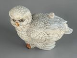 a white owl figurine sitting on a gray surface
