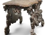 a wooden table with a carved top on wheels