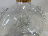 a clear glass bottle with a gold top on a white background