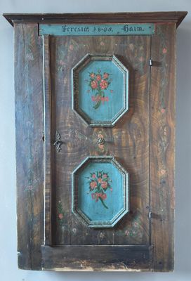 a wall mounted clock with three flowers painted on it