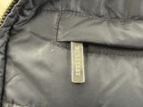 a close up of a black jacket with a tag on it