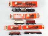 cinq types différents de petits trains sur une surface blanche