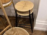 baskets and stools in a room with wooden flooring and white walls