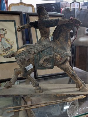a statue of a man riding a horse on a glass table