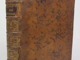 an old book sitting on top of a white table next to a white wall