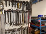many wrenches hanging on the wall in a garage