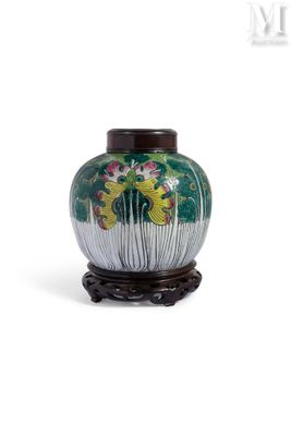 un vase vert orné de fleurs, posé sur un socle