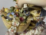 a figurine of a woman holding a basket of flowers