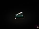a close up of a green diamond on a black surface