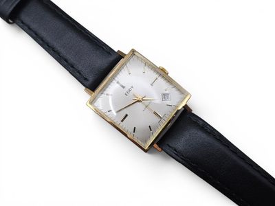une image d'un gros plan d'une montre-bracelet sur une surface blanche