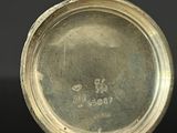 a close up of a silver plate on a black surface