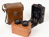 two old cameras sitting next to each other on a white surface