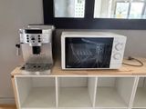 un micro-ondes et une cafetière posés sur une étagère