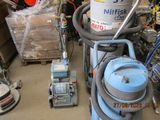 une photo d'une pièce où se trouvent un aspirateur et d'autres objets