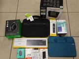 un ordinateur portable et d'autres appareils électroniques posés par terre à côté d'un sac