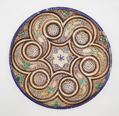 une image représentant une assiette décorative posée sur une surface blanche